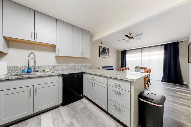 a kitchen with granite countertop cabinets stainless steel appliances and a sink