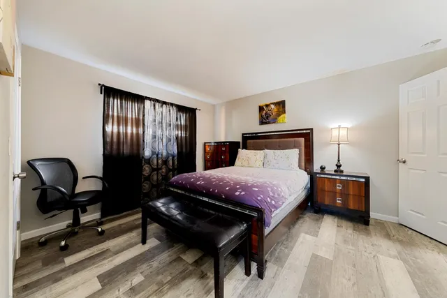 a bedroom with a bed and wooden floor