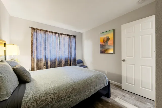 a bedroom with a bed and wooden floor