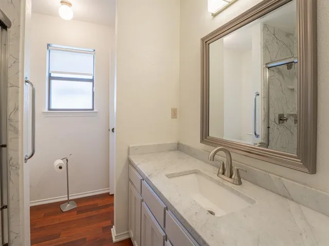 a bathroom with a granite countertop sink and a mirror