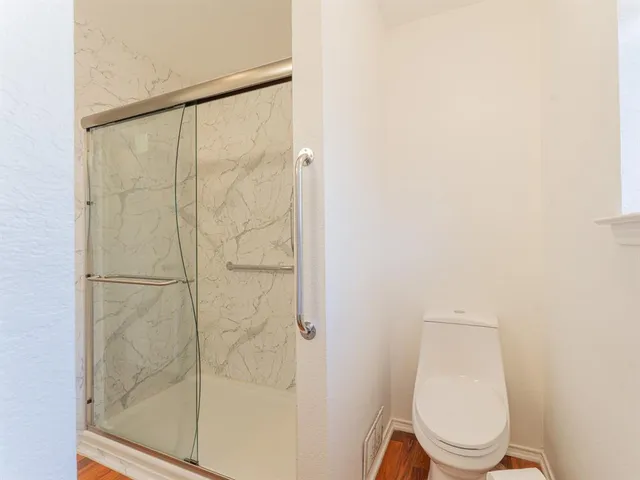 a white toilet sitting next to a shower