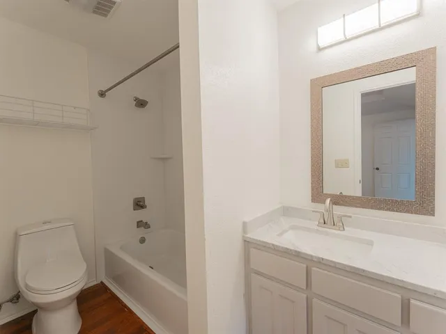 a bathroom with a granite countertop sink a toilet and a bathtub