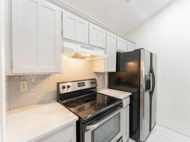 a kitchen with stainless steel appliances granite countertop a refrigerator and a stove