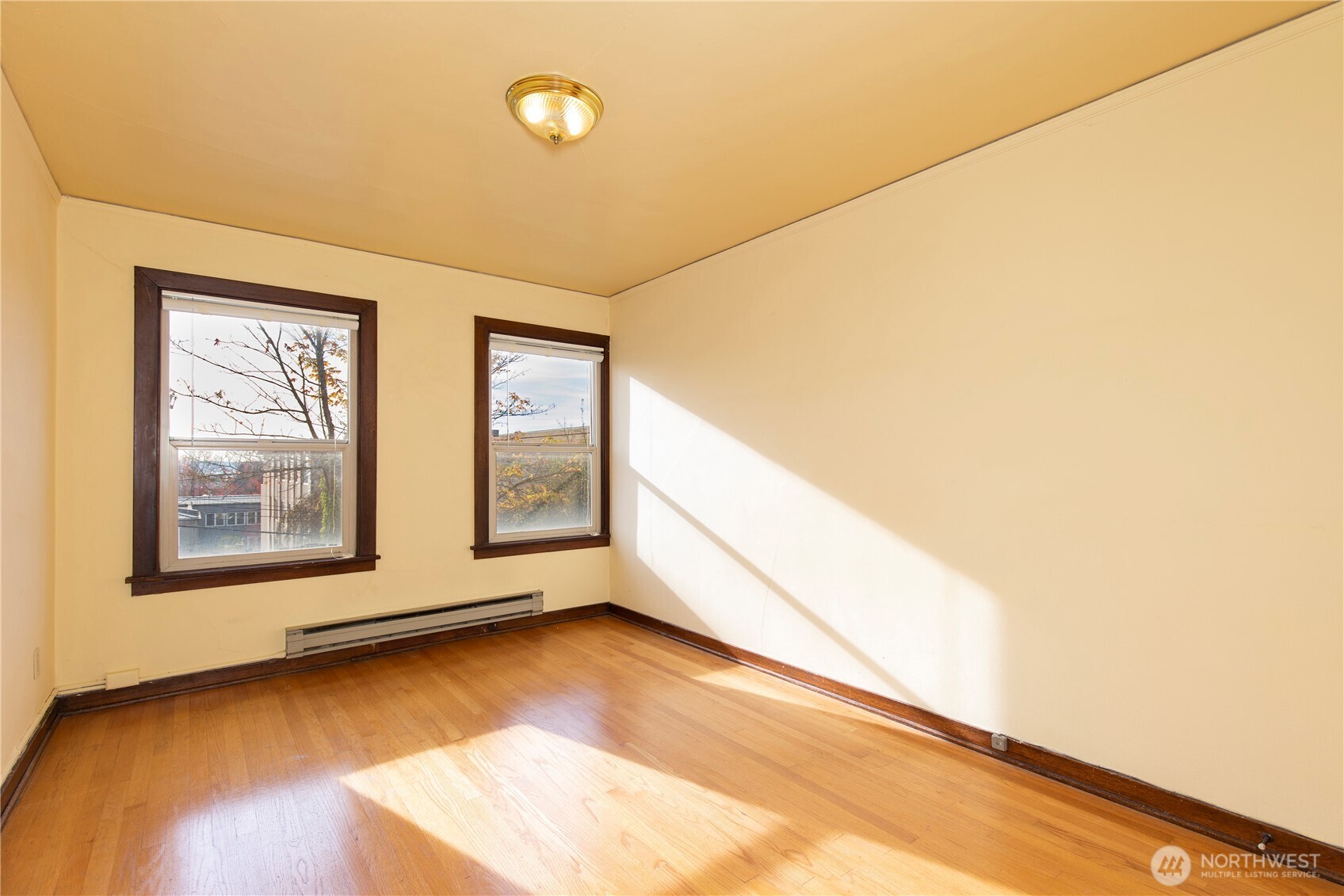 16 Valley Street Seattle, WA 98109 - Photo 18 of 40 a view of an empty room with wooden floor and a window