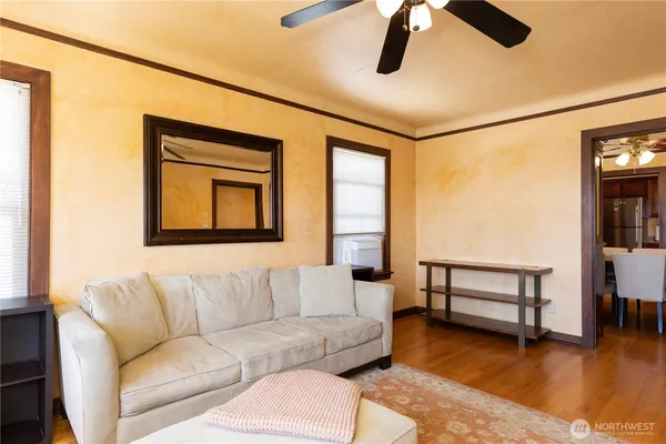 a living room with couches a dining table and chairs with wooden floor