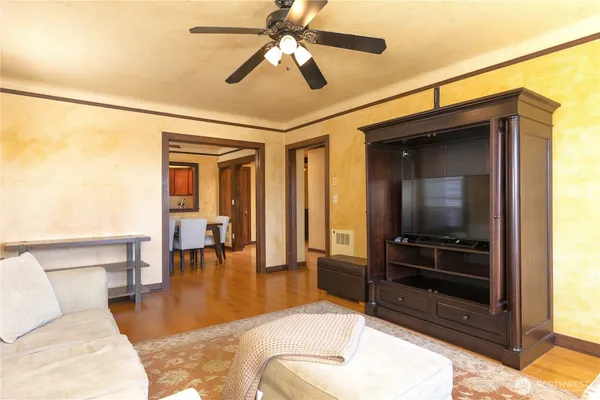 a view of an empty room with a window and wooden floor