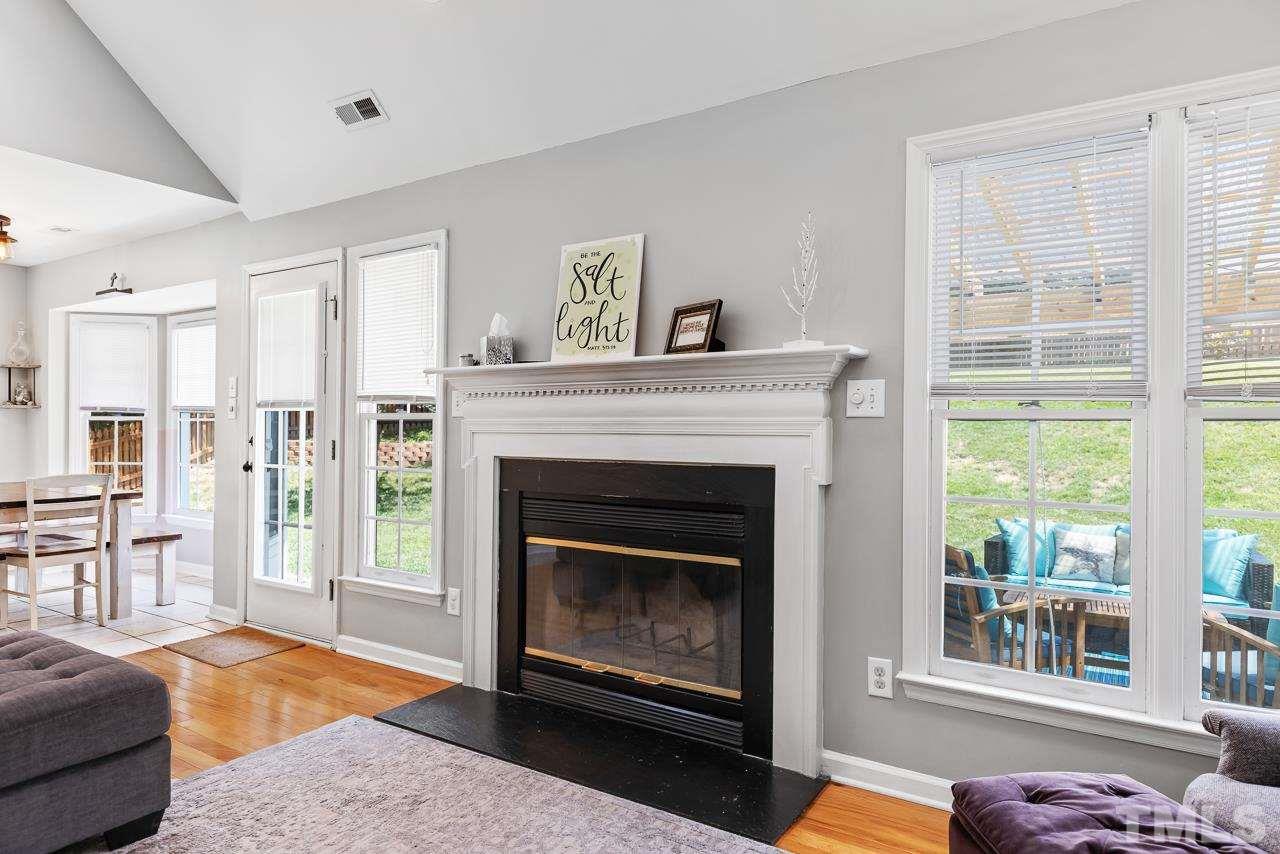 5201 Sutter Way Raleigh, NC 27613 - Photo 7 of 29 Fireplace is flanked by windows overlooking the private, fenced backyard.
