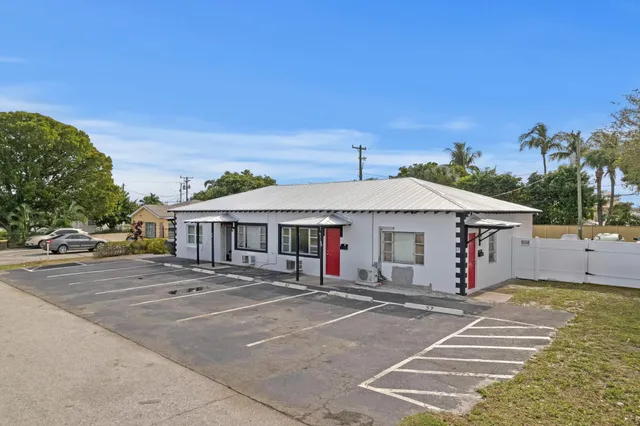 a view of a white house with a large space