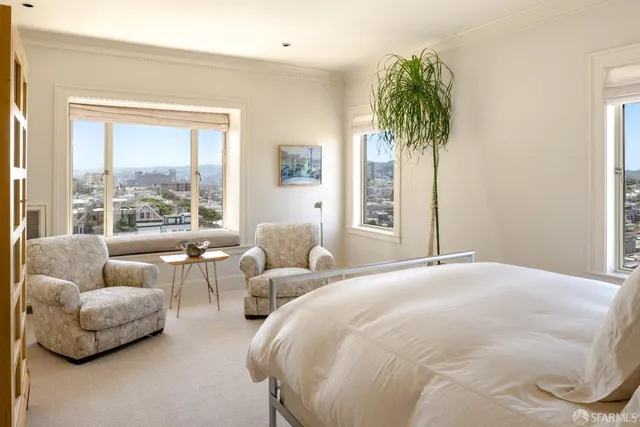 a bedroom with furniture and a large window