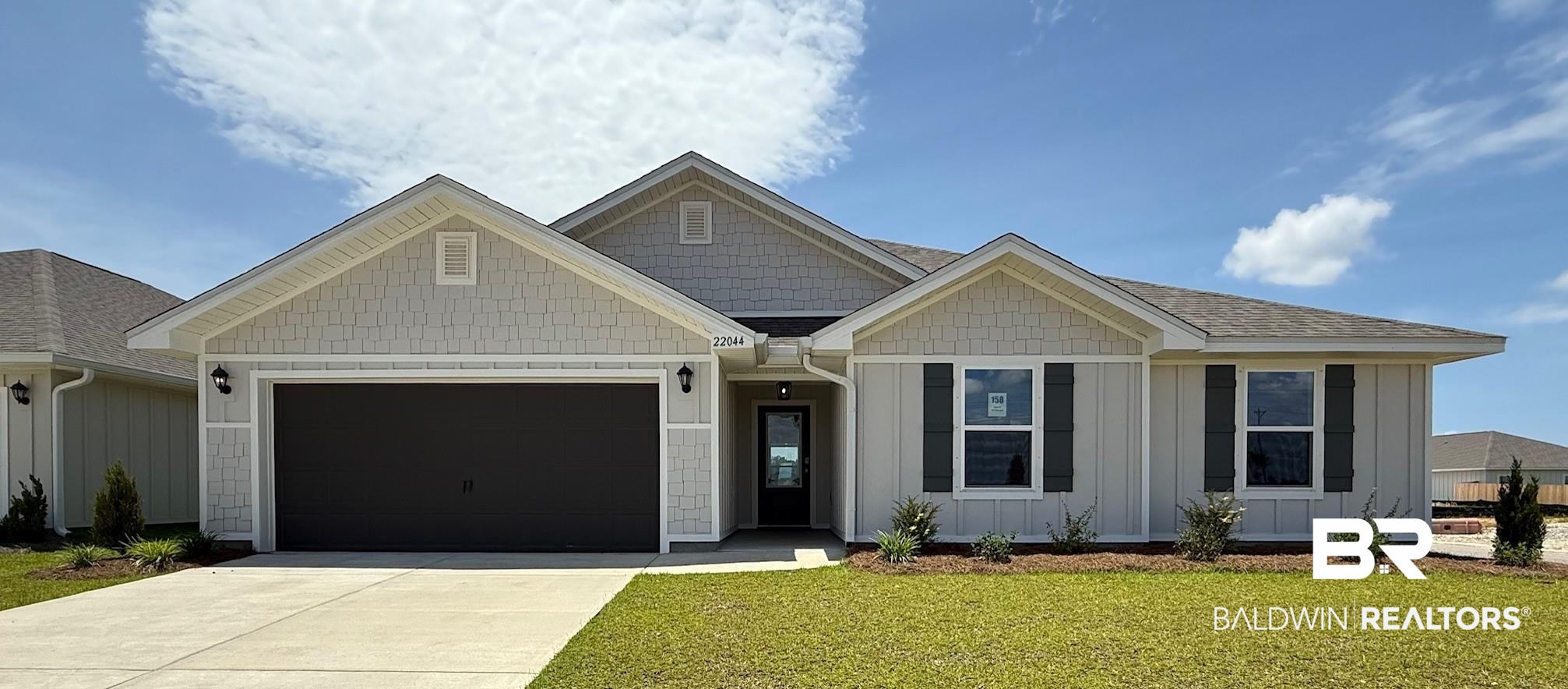 22044 Aleutian Avenue Foley, AL 36535 - Photo 1 of 28 View of front of property with a garage, concrete driveway, board and batten siding, and a front lawn