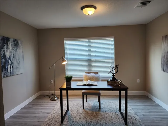 a view of a workspace with furniture and a window