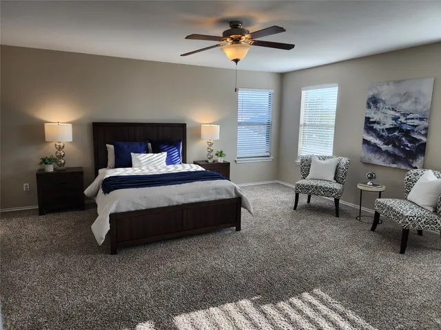 a bedroom with a bed a couch and a chandelier