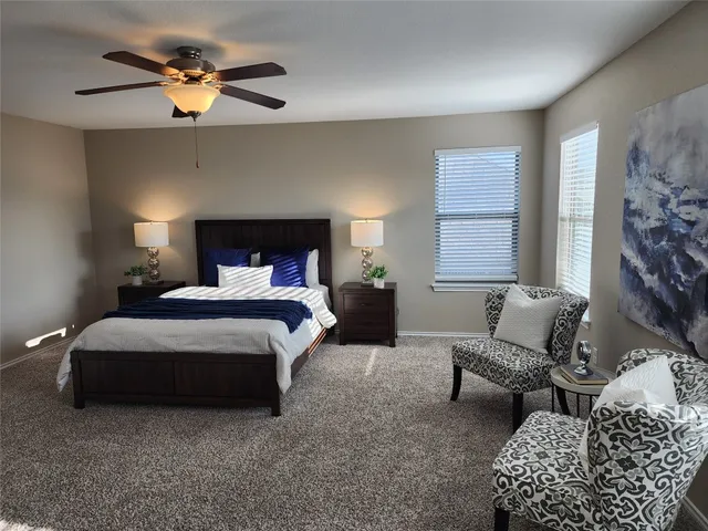 a bedroom with bed couch and window