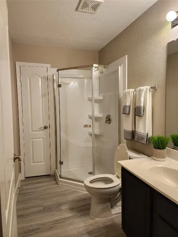 a bathroom with a sink a toilet and shower
