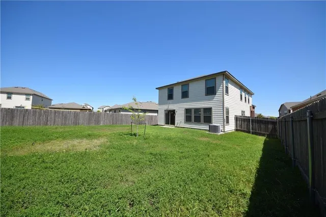a view of a house with a big yard plants and large trees