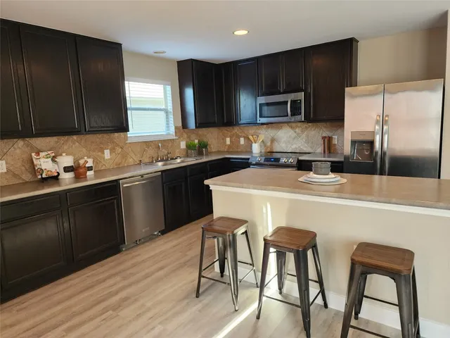a kitchen with stainless steel appliances wooden floors and wooden cabinets