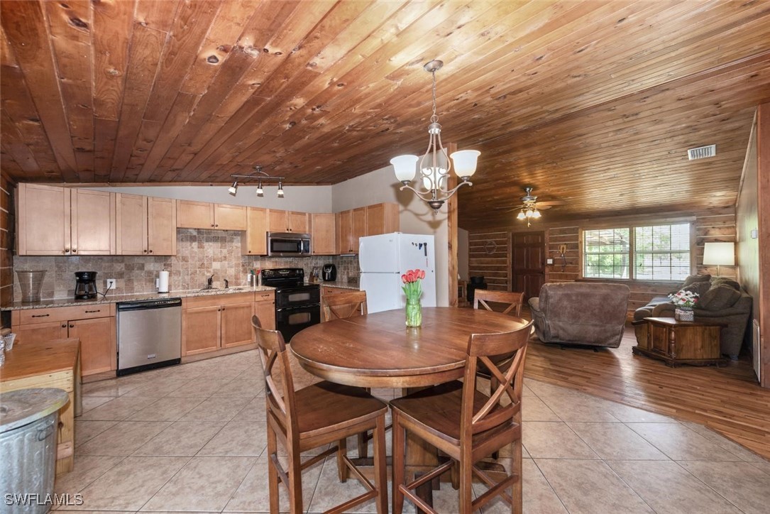 47350 Bermont Road Punta Gorda, FL 33982 - Photo 23 of 41 a kitchen with a dining table chairs stainless steel appliances and cabinets