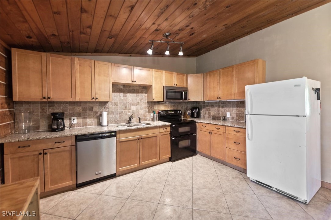 47350 Bermont Road Punta Gorda, FL 33982 - Photo 28 of 41 a kitchen with granite countertop a refrigerator a sink dishwasher a stove top oven a refrigerator and cabinets