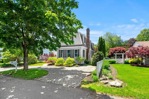 a front view of a house with a yard and trees