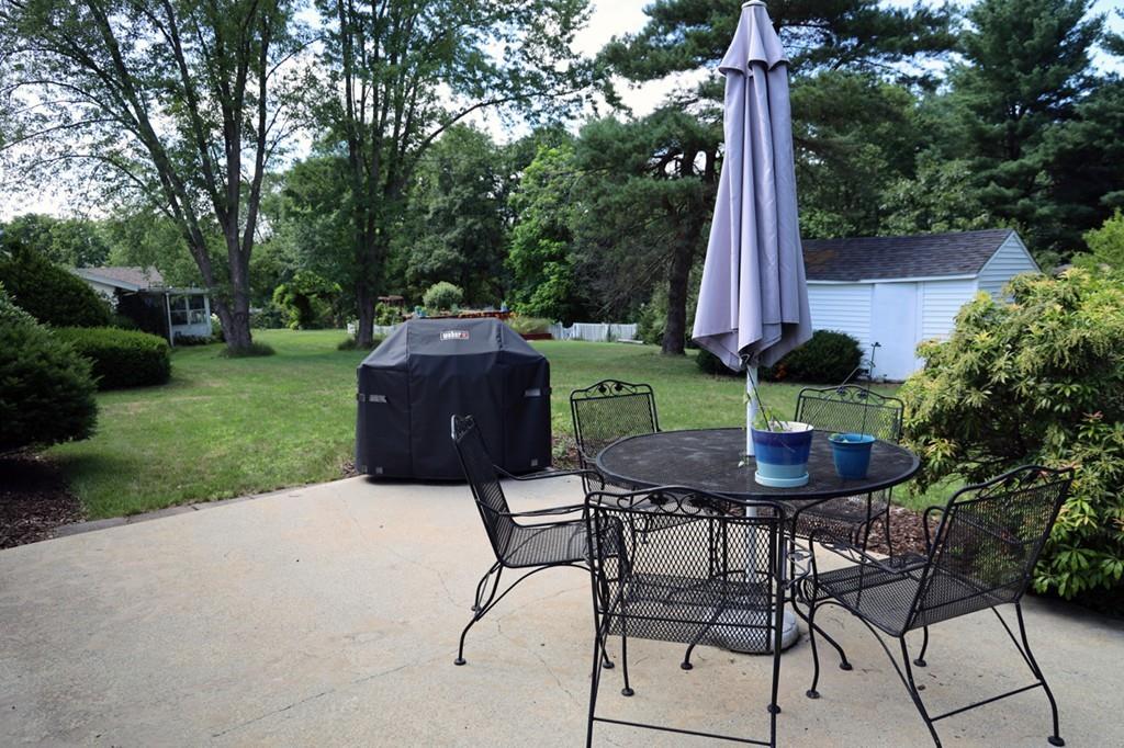 14 Catherine Road Framingham, MA 01701 - Photo 23 of 24 a backyard with a table and chairs and a large tree