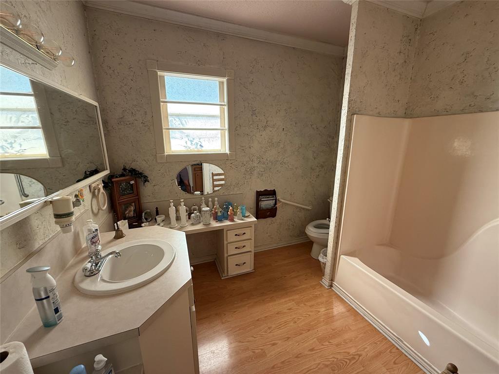 507 South Jackson Street Kaufman, TX 75142 - Photo 12 of 16 a bathroom with a sink a toilet and tub
