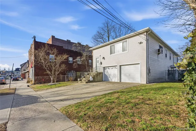 a view of a house with a big yard and garage