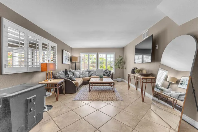 a living room with furniture a fireplace and a large window