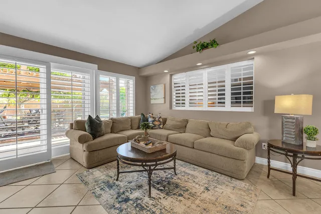 a view of a patio with table and chairs potted plants with floor to ceiling window with wooden floor