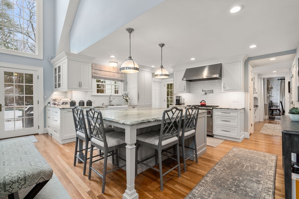 135 Glen Road Wellesley, MA 02481 - Photo 8 of 33 a kitchen with stainless steel appliances kitchen island granite countertop a table chairs sink and cabinets