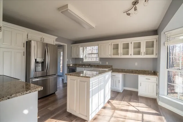 a kitchen with stainless steel appliances granite countertop a refrigerator a stove and a sink