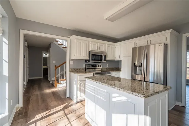 a view of empty room with wooden floor and windows