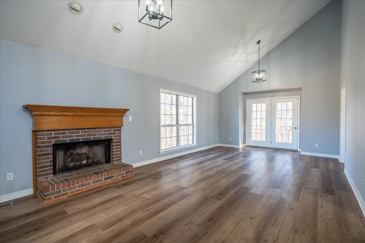 1126 Crowder Road Lawrenceburg, TN 38464 - Photo 23 of 50 an empty room with wooden floor fireplace and windows