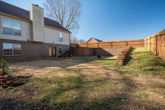 a view of a house with backyard and sitting area