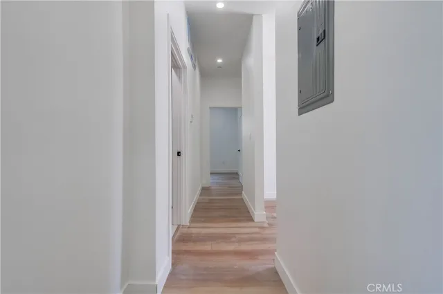 a view of a hallway with wooden floor and staircase