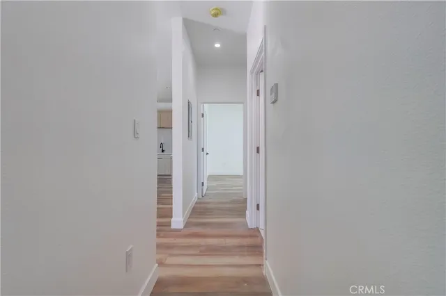 a view of a hallway with wooden floor and staircase
