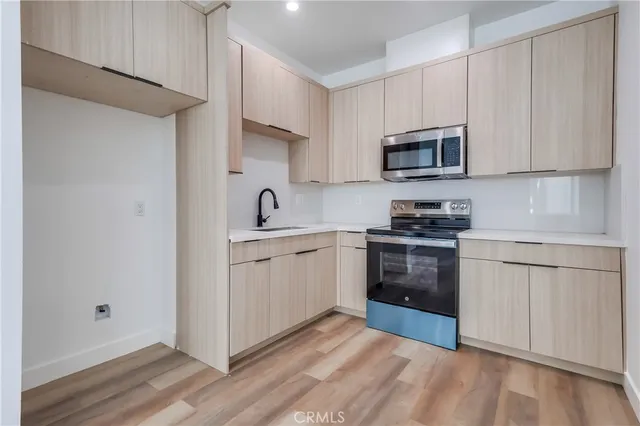 a kitchen with white cabinets stainless steel appliances and sink