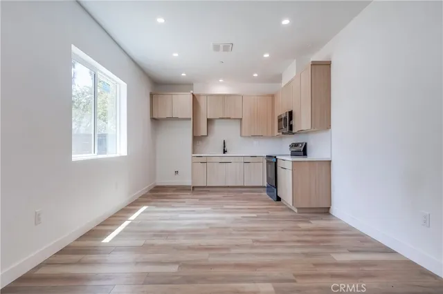 a view of kitchen with wooden floor and electronic appliances