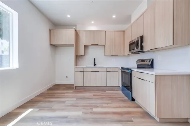 a kitchen with white cabinets stainless steel appliances and sink