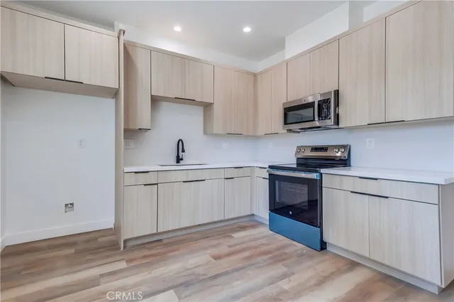a kitchen with stainless steel appliances granite countertop a stove a sink and a refrigerator