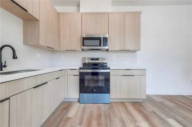 a kitchen with granite countertop white cabinets and stainless steel appliances