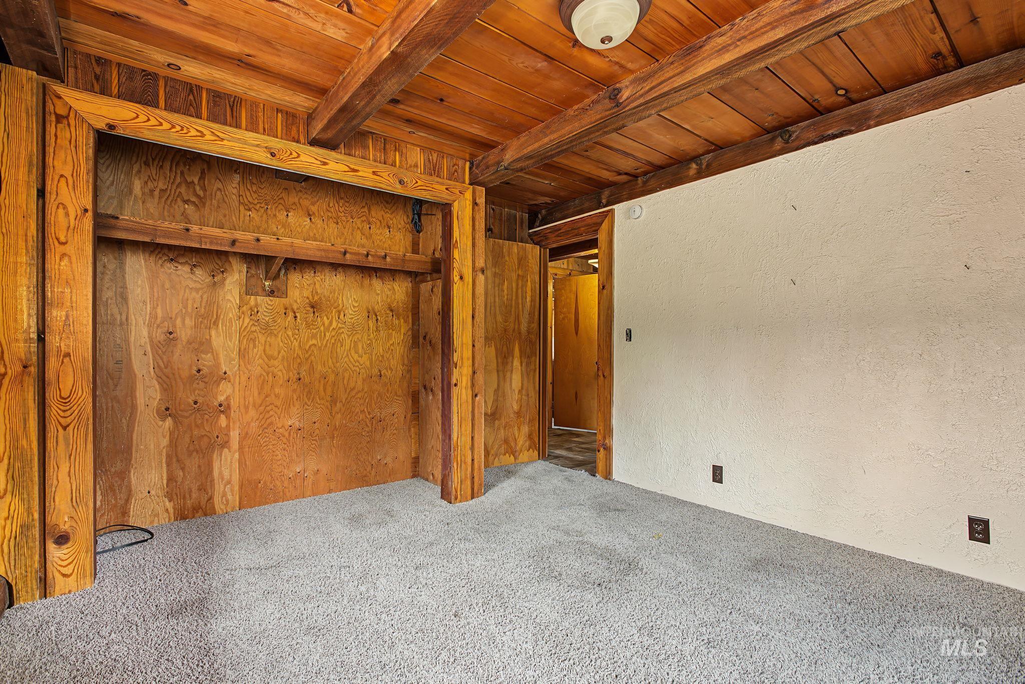 2926 Wells Bench Road Orofino, ID 83544 - Photo 33 of 48 Wood-paneled ceilings with exposed beams, light gray carpeting, and a built-in wardrobe