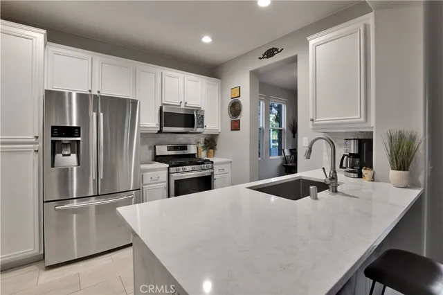 a kitchen with granite countertop a refrigerator stove and sink
