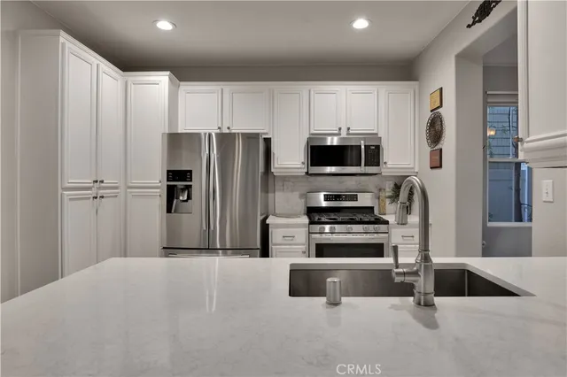 a kitchen with kitchen island a counter top space stainless steel appliances and cabinets