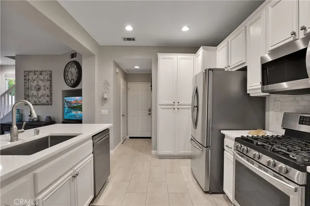 a kitchen with stainless steel appliances granite countertop a refrigerator stove and sink