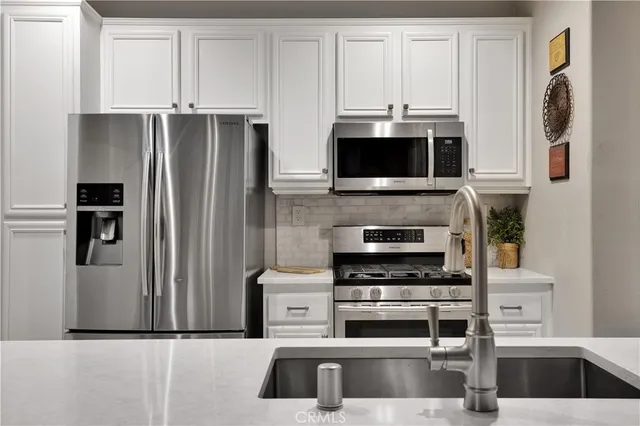 a kitchen with stainless steel appliances a stove a microwave and a refrigerator