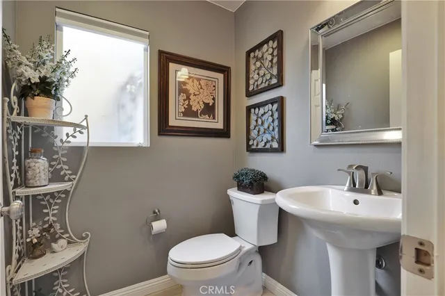 a bathroom with a toilet a sink and mirror