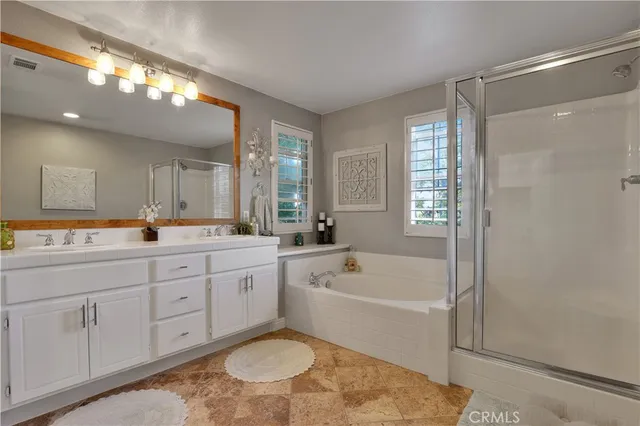 a spacious bathroom with a tub sink shower and mirror
