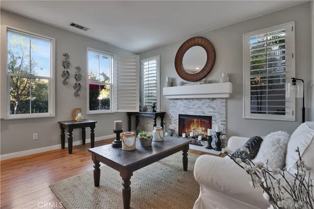 a living room with furniture a rug a fireplace and windows
