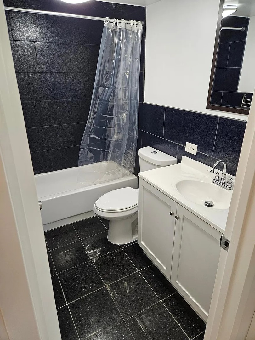 300 South Roselle Road, Unit 111 Schaumburg, IL 60193 - Photo 11 of 13 a white toilet sitting next to a sink and vanity