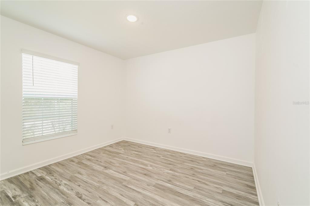 1473 Lucerne Loop Road Northeast Winter Haven, FL 33881 - Photo 14 of 25 a view of empty room with wooden floor and fan